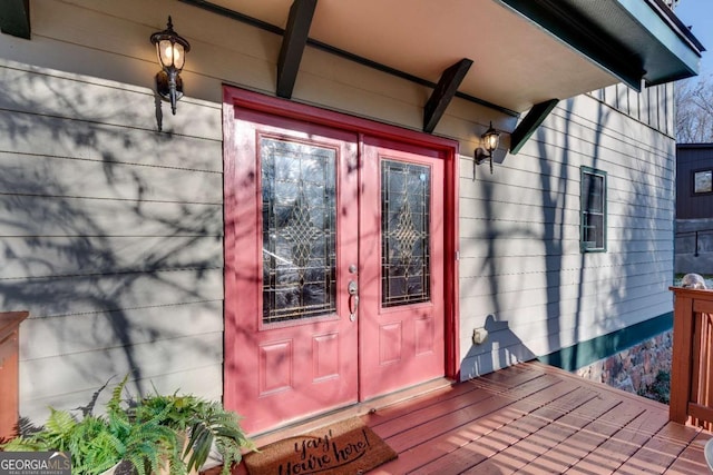 property entrance featuring a wooden deck and french doors