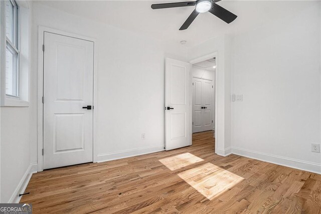 empty room with light wood-type flooring and ceiling fan