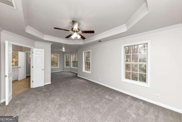 unfurnished bedroom featuring ceiling fan, crown molding, a raised ceiling, and carpet flooring