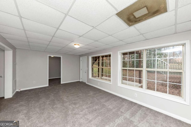 basement with carpet and a paneled ceiling