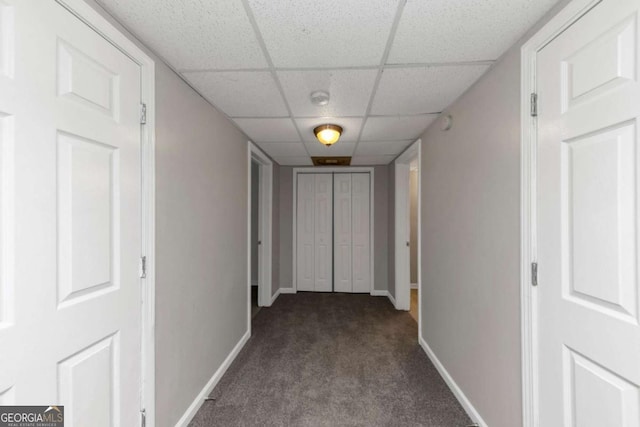 hallway featuring carpet and a drop ceiling