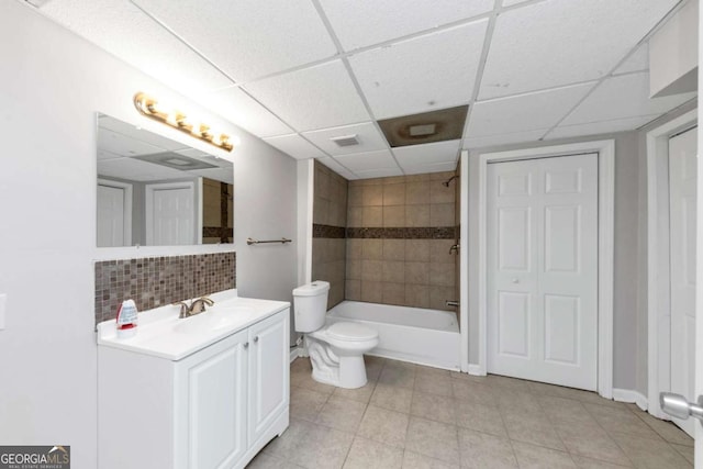 full bathroom featuring toilet, a paneled ceiling, decorative backsplash, and vanity