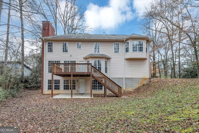 back of house featuring a deck and a patio