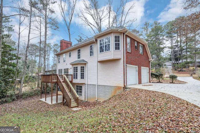 rear view of property with a garage and a deck