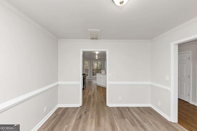 empty room featuring light hardwood / wood-style flooring and ornamental molding