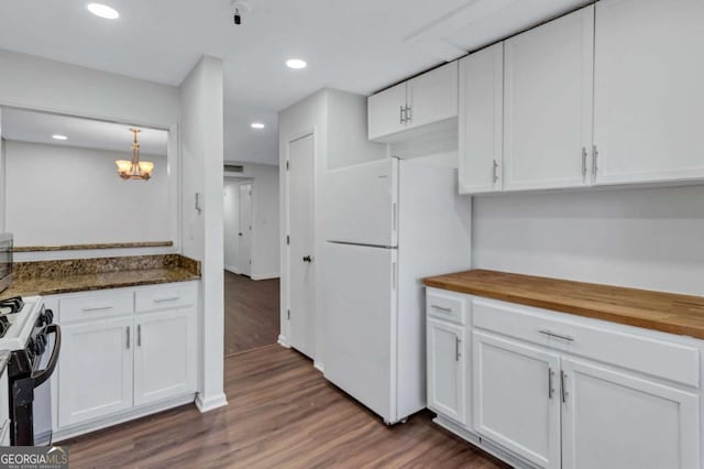 kitchen featuring white cabinets, gas stove, white fridge, and butcher block countertops