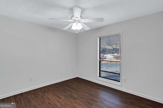 spare room with ceiling fan and dark wood-type flooring