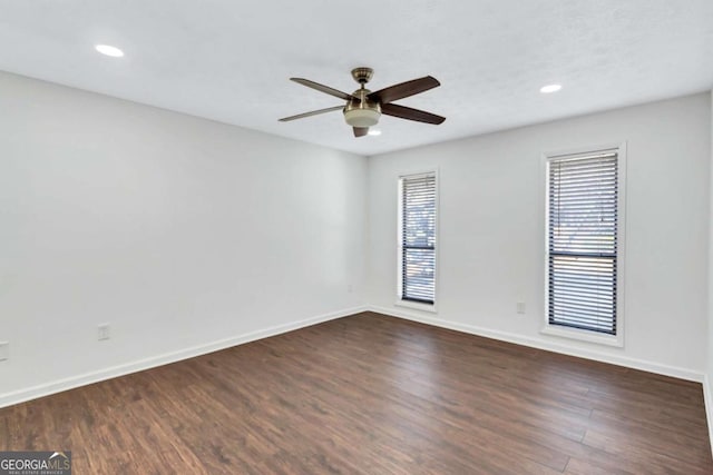 spare room with ceiling fan and dark hardwood / wood-style flooring