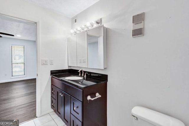 bathroom featuring tile patterned floors, toilet, vanity, and a textured ceiling