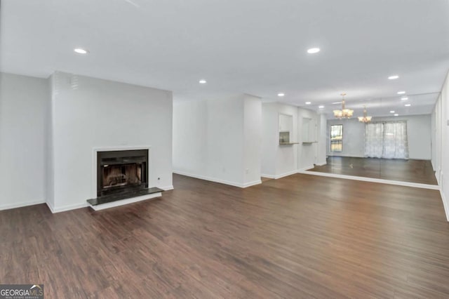 unfurnished living room featuring a chandelier and dark hardwood / wood-style flooring