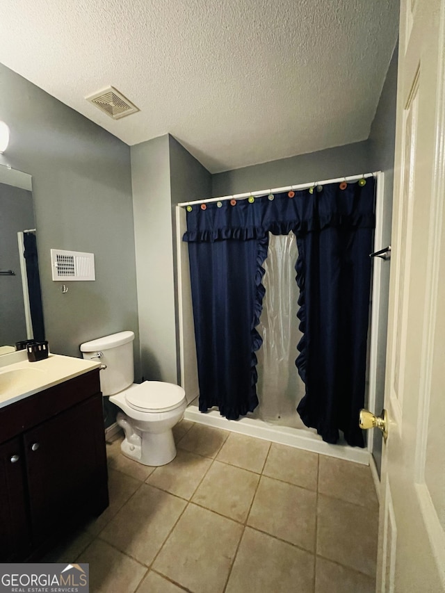 full bathroom featuring vanity, toilet, a textured ceiling, and tile patterned flooring