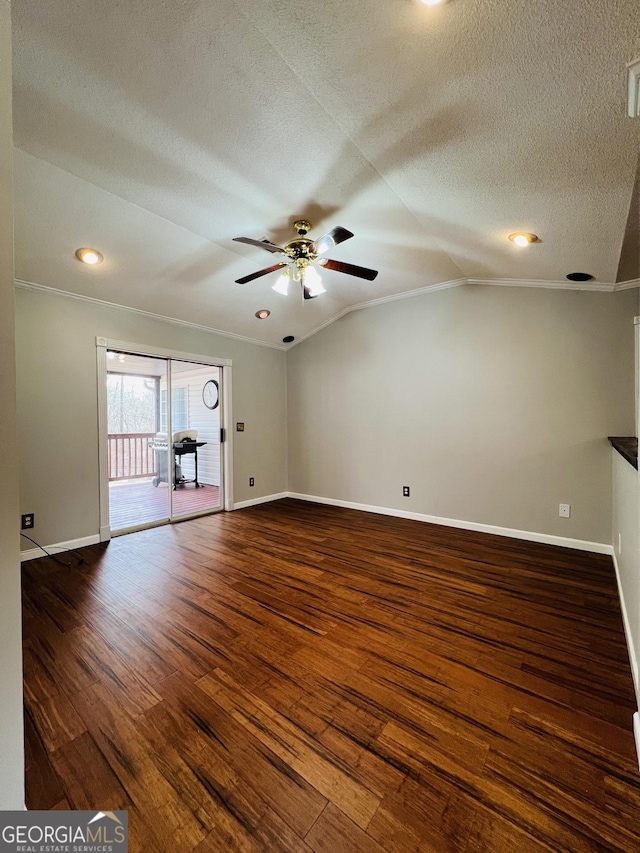 empty room featuring ceiling fan, a textured ceiling, ornamental molding, dark wood-type flooring, and vaulted ceiling