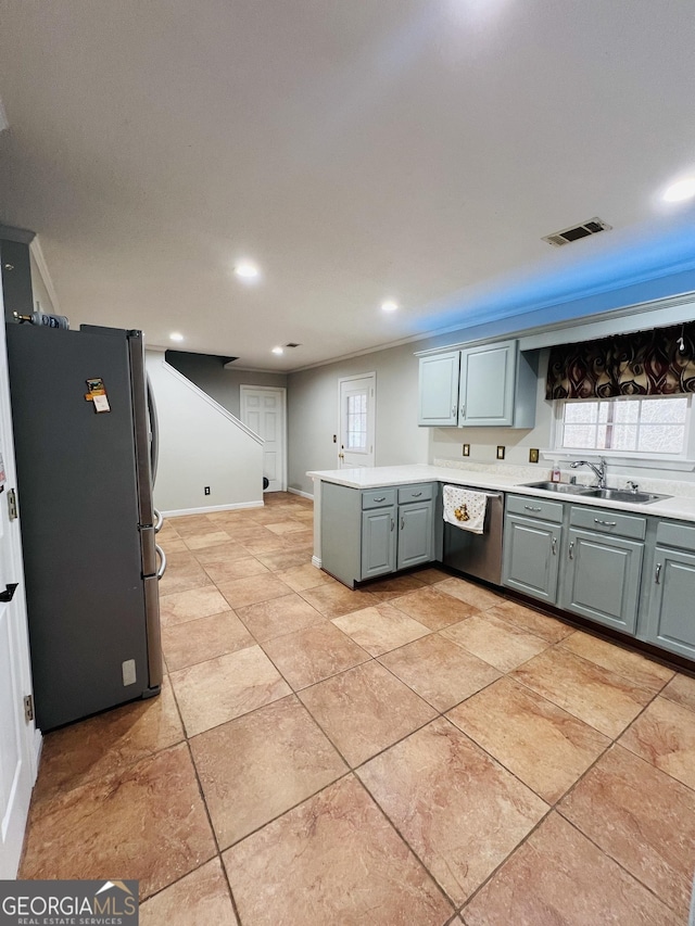 kitchen with light tile patterned floors, sink, appliances with stainless steel finishes, and kitchen peninsula