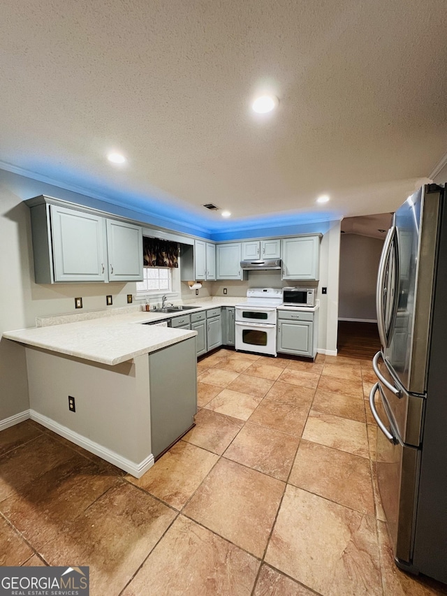 kitchen with a textured ceiling, stainless steel refrigerator, sink, kitchen peninsula, and double oven range