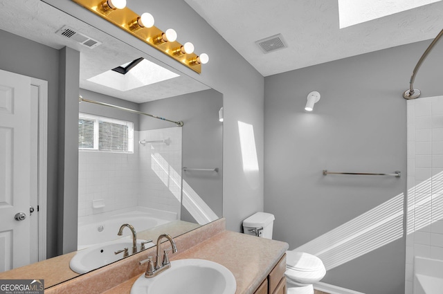 bathroom with vanity, toilet, and a textured ceiling