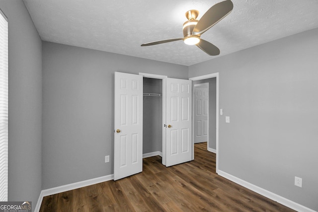 unfurnished bedroom featuring ceiling fan, dark hardwood / wood-style floors, a textured ceiling, and a closet