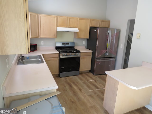 kitchen featuring light brown cabinetry, sink, kitchen peninsula, stainless steel appliances, and light wood-type flooring