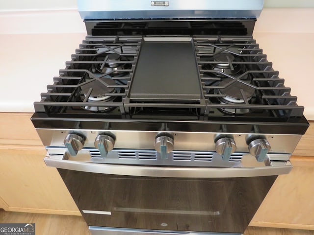 room details featuring hardwood / wood-style floors and gas range