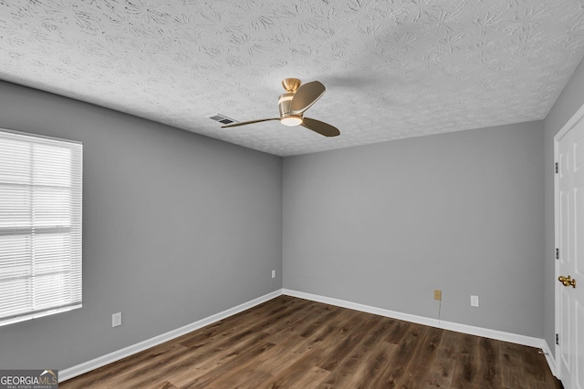 spare room with dark hardwood / wood-style flooring, a textured ceiling, and ceiling fan