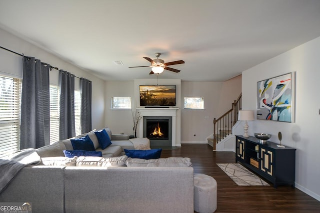 living room featuring dark wood-type flooring and ceiling fan