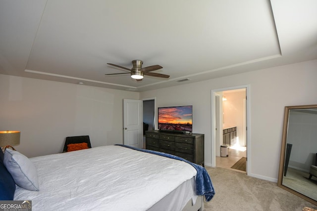 carpeted bedroom featuring a raised ceiling and ceiling fan