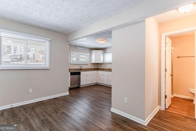 kitchen with a textured ceiling, dishwasher, white cabinets, sink, and dark hardwood / wood-style flooring