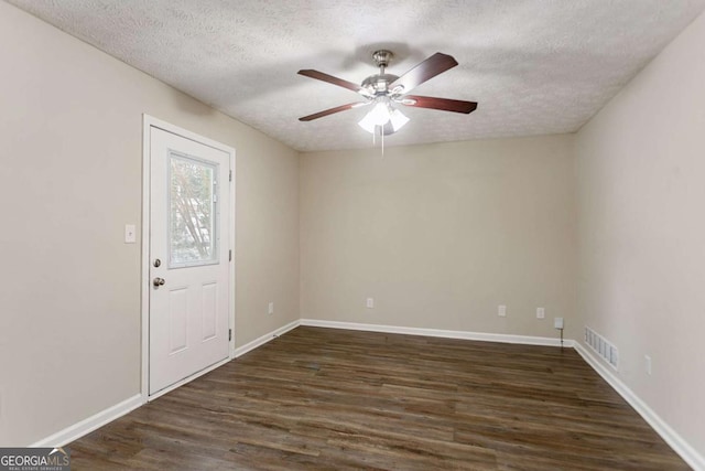 unfurnished room with a textured ceiling, ceiling fan, and dark hardwood / wood-style flooring