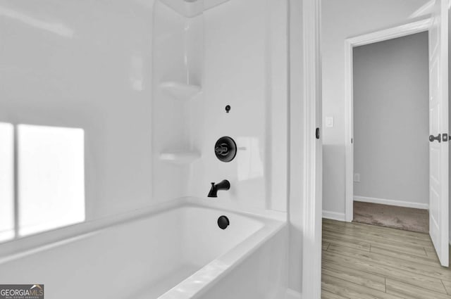 bathroom featuring hardwood / wood-style flooring and  shower combination