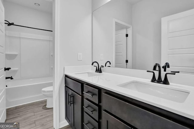 full bathroom featuring  shower combination, hardwood / wood-style flooring, toilet, and vanity