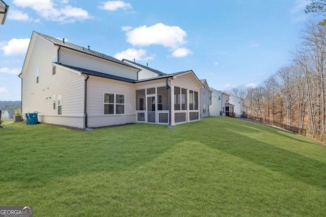 rear view of house featuring a sunroom, a yard, and central AC