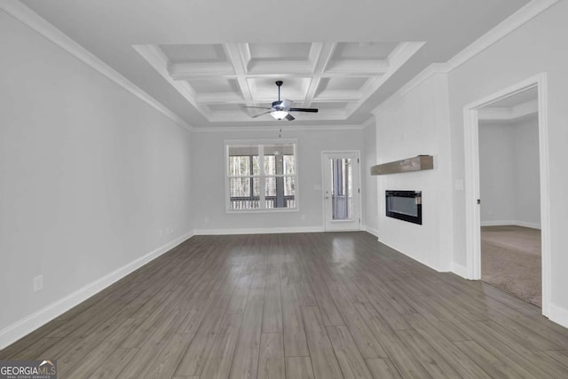 unfurnished living room featuring beam ceiling, dark wood-type flooring, ornamental molding, and coffered ceiling