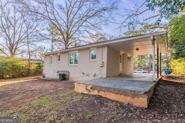 rear view of house featuring central air condition unit and a carport