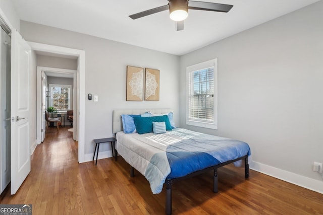 bedroom featuring wood-type flooring, multiple windows, and ceiling fan