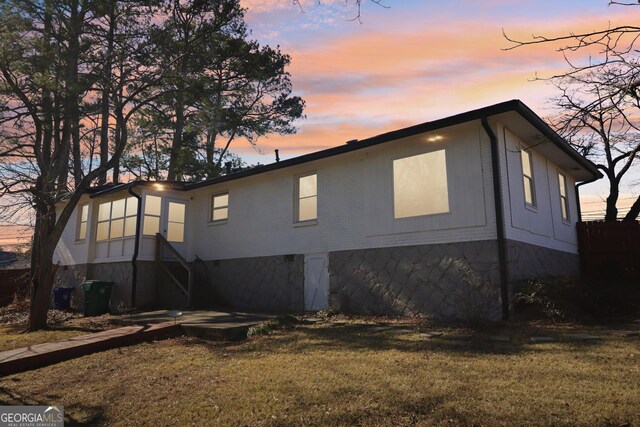 property exterior at dusk with a yard