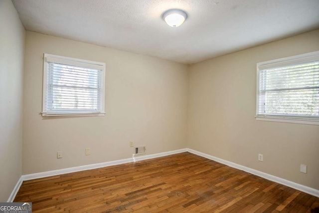 spare room featuring wood-type flooring