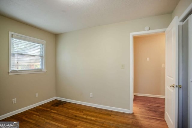 spare room with dark wood-type flooring