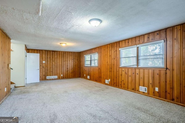 carpeted empty room with a textured ceiling