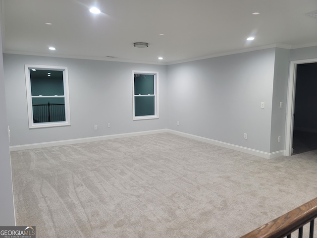 empty room featuring ornamental molding and light carpet