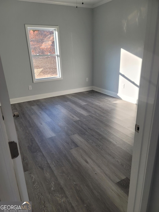 unfurnished room featuring dark hardwood / wood-style flooring and crown molding