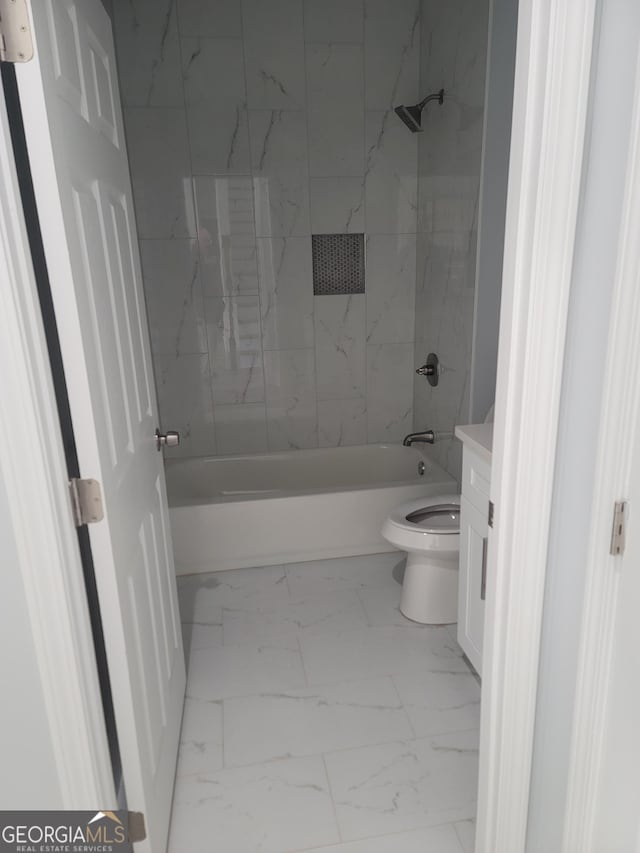 full bathroom featuring tiled shower / bath, vanity, and toilet