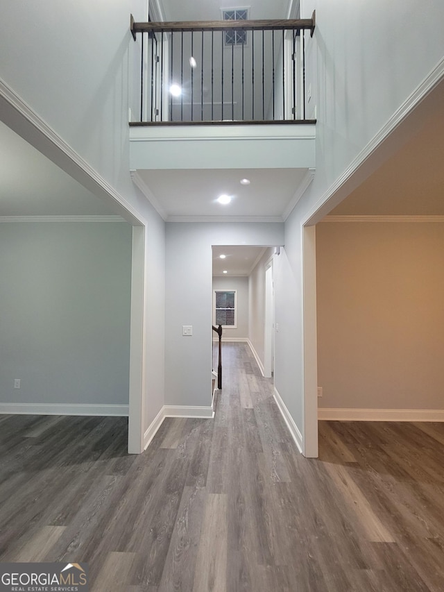 hallway featuring wood-type flooring and ornamental molding