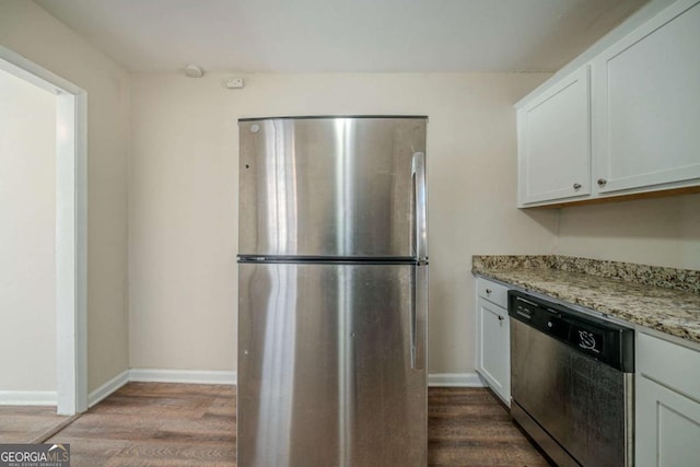 kitchen featuring hardwood / wood-style flooring, light stone countertops, white cabinetry, and appliances with stainless steel finishes