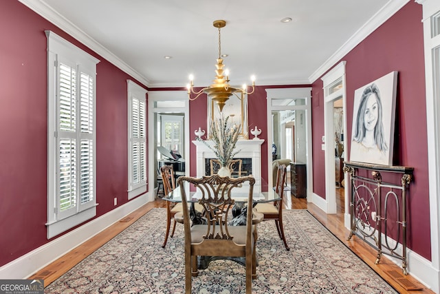 dining room featuring hardwood / wood-style flooring, ornamental molding, and a chandelier