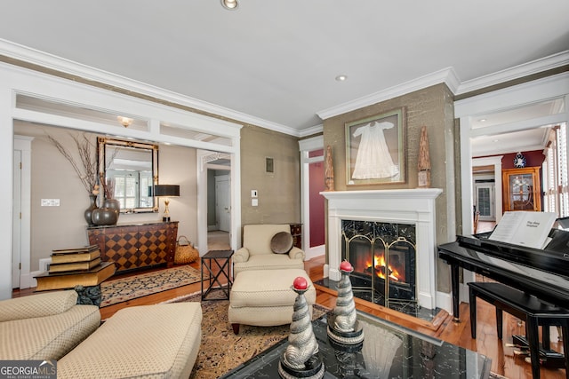 living room featuring hardwood / wood-style flooring, a healthy amount of sunlight, a fireplace, and crown molding