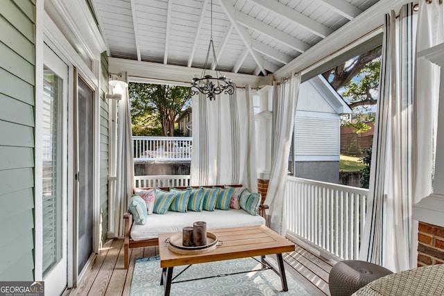 sunroom / solarium featuring vaulted ceiling with beams and an inviting chandelier