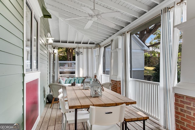 sunroom / solarium featuring ceiling fan, wooden ceiling, lofted ceiling with beams, and a wealth of natural light