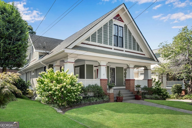 view of front of house with a front yard and a porch