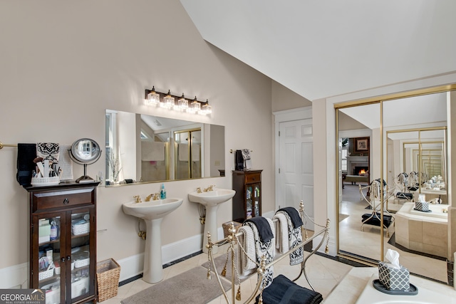 bathroom featuring vaulted ceiling, dual sinks, and tile patterned floors