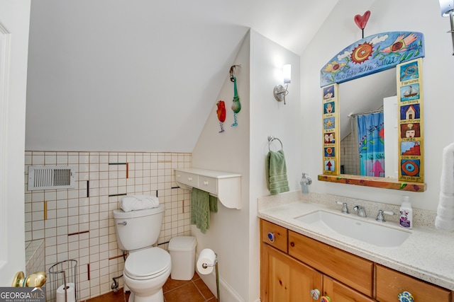 bathroom with lofted ceiling, vanity, tile patterned floors, and toilet