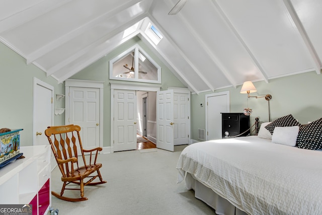 carpeted bedroom with ceiling fan and lofted ceiling with skylight